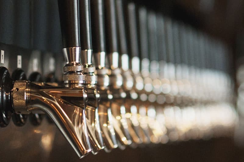 Close-up of a long row of shiny beer taps at Iron Tap Station taproom
