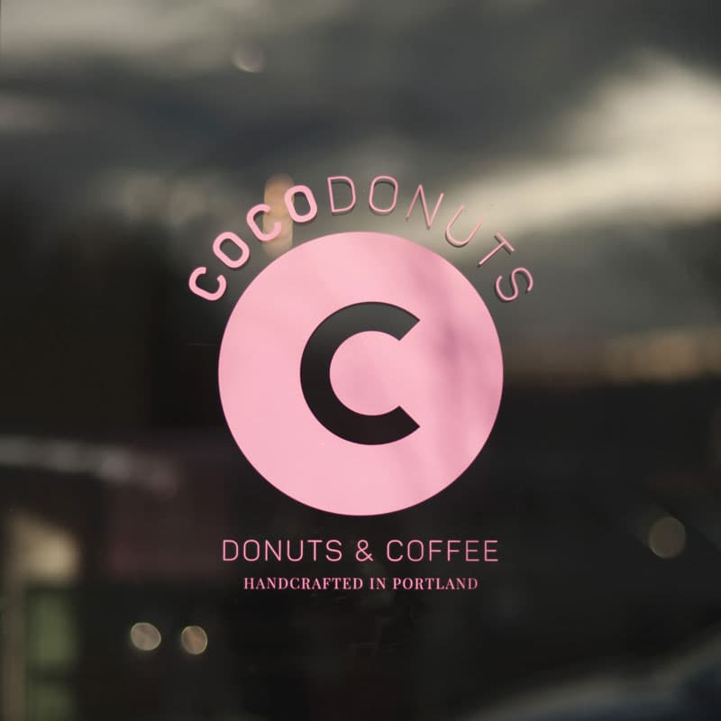 Coco Donuts' pink logo and "Donuts & Coffee" lettering on a shop window in Portland