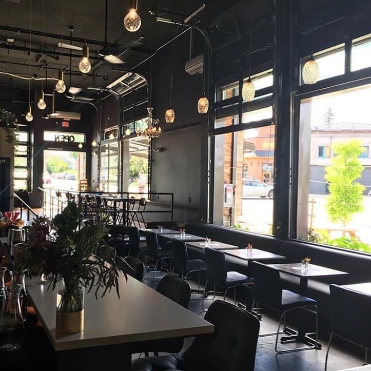 Grand Army Tavern dining room with dark banquettes, tables, pendant lights and large windows