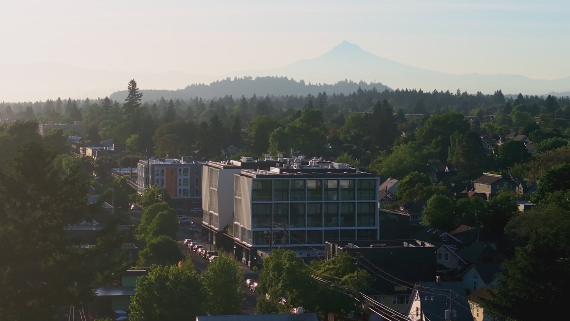 Aerial view of Cascada in Portland's Alberta Arts District at dusk, with Mount Hood on the horizon